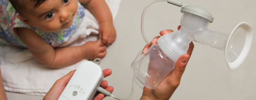 baby looking at breast pump