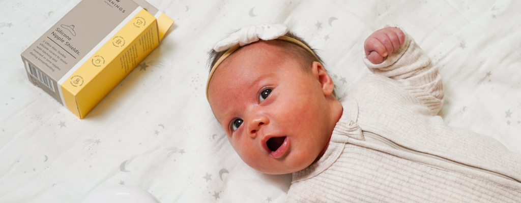 baby laying next to a new beginnings nipple shield